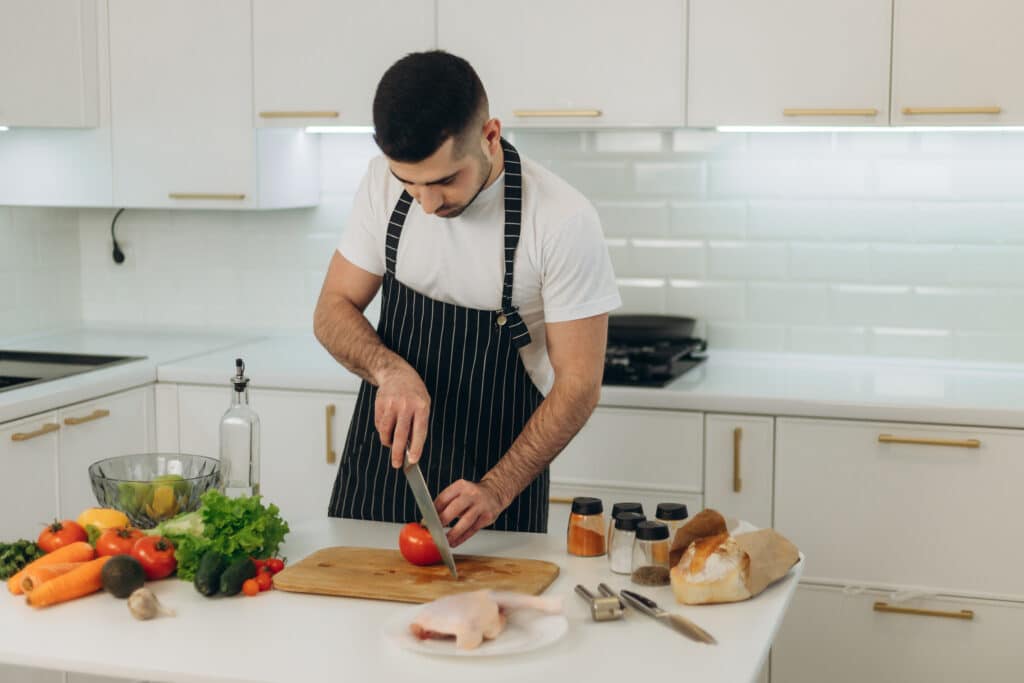 About Me 1 Aaron preparing vegetables on a cutting board in a modern kitchen