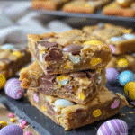 How to Make the Best Mini Egg Cookie Bars Ever 11 mini egg cookie bars stacked on dessert plate for serving